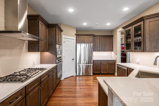 807 Hollybrook Dr, Flat Rock, NC 28731 - kitchen featuring stainless steel appliances, wall chimney range hood, dark brown cabinetry, tasteful backsplash, and wood finished floors