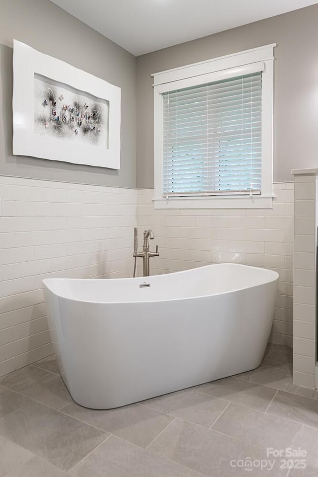 807 Hollybrook Dr, Flat Rock, NC 28731 - full bathroom featuring tile walls, a freestanding tub, a wainscoted wall, and tile patterned flooring