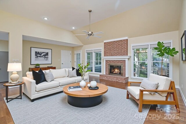 140 Rustic Way Ln, Mooresville, NC 28117 - living area featuring vaulted ceiling, wood finished floors, a ceiling fan, and a brick fireplace