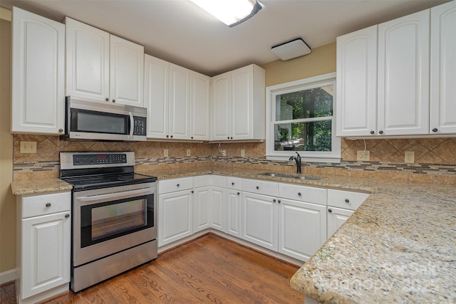 140 Rustic Way Ln, Mooresville, NC 28117 - kitchen with appliances with stainless steel finishes, wood finished floors, white cabinets, and light stone countertops