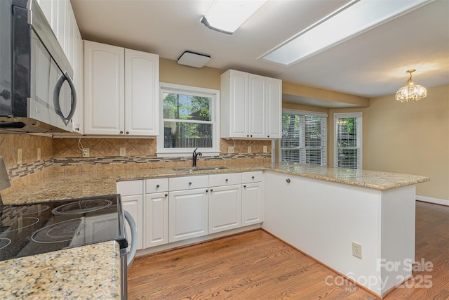 140 Rustic Way Ln, Mooresville, NC 28117 - kitchen featuring appliances with stainless steel finishes, a peninsula, light wood-style floors, and white cabinets