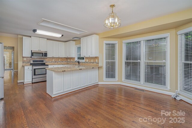 140 Rustic Way Ln, Mooresville, NC 28117 - kitchen featuring stainless steel appliances, white cabinets, decorative backsplash, dark wood-type flooring, and light stone countertops
