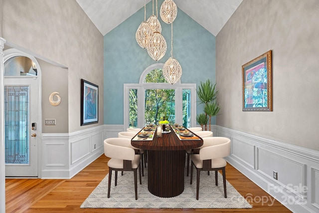 15724 Eagleview Dr, Charlotte, NC 28278 - dining space with a chandelier, wood finished floors, high vaulted ceiling, and a wainscoted wall