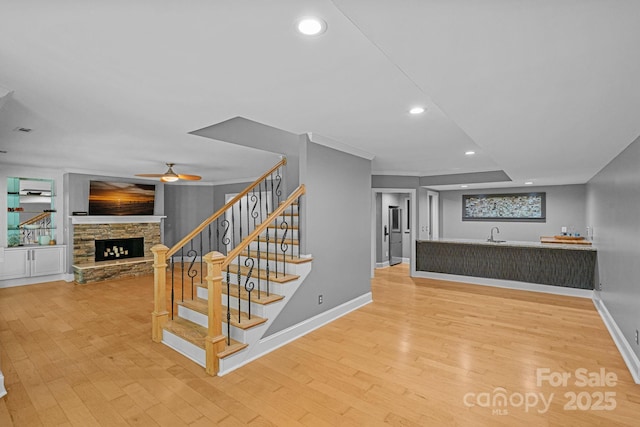 15724 Eagleview Dr, Charlotte, NC 28278 - staircase featuring wood finished floors, a fireplace, ceiling fan, recessed lighting, and ornamental molding