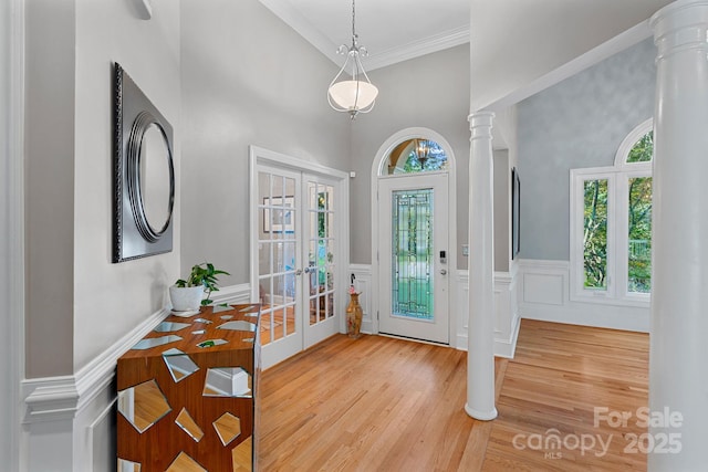 15724 Eagleview Dr, Charlotte, NC 28278 - entrance foyer featuring a towering ceiling, ornate columns, ornamental molding, light wood-style floors, and a wainscoted wall