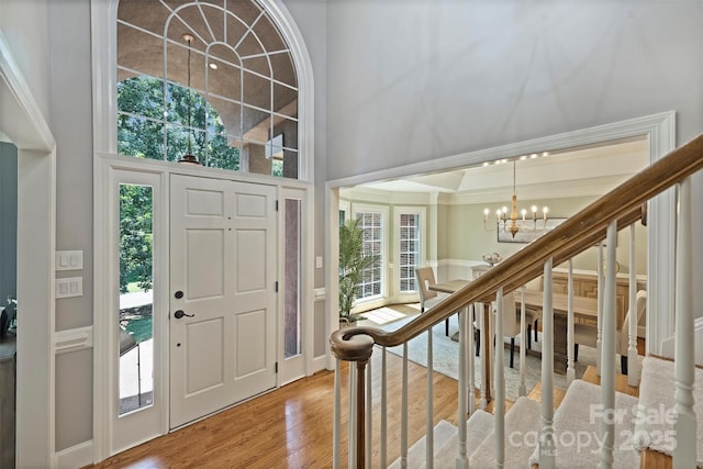 2317 Houston Branch Rd, Charlotte, NC 28270 - entrance foyer with a chandelier, crown molding, wood finished floors, stairs, and a high ceiling