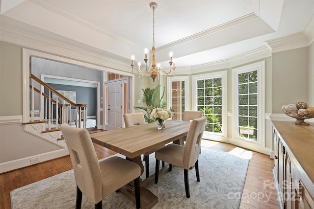 2317 Houston Branch Rd, Charlotte, NC 28270 - dining space with a chandelier, stairway, light wood-style flooring, a tray ceiling, and ornamental molding