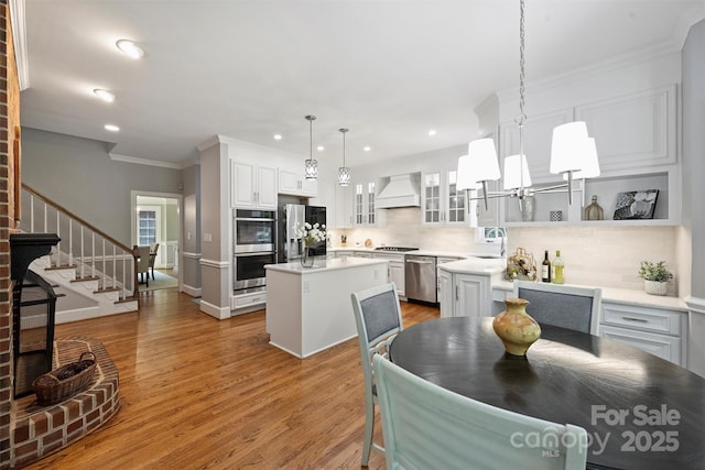 2317 Houston Branch Rd, Charlotte, NC 28270 - kitchen with custom range hood, stainless steel appliances, a center island, backsplash, and glass insert cabinets