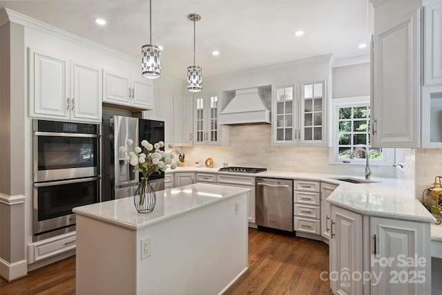 2317 Houston Branch Rd, Charlotte, NC 28270 - kitchen featuring appliances with stainless steel finishes, premium range hood, light stone countertops, white cabinetry, and ornamental molding