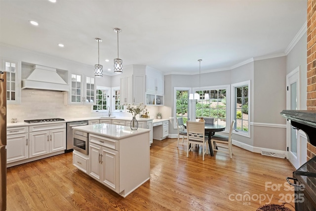 2317 Houston Branch Rd, Charlotte, NC 28270 - kitchen with custom exhaust hood, gas cooktop, a chandelier, white cabinetry, and light countertops