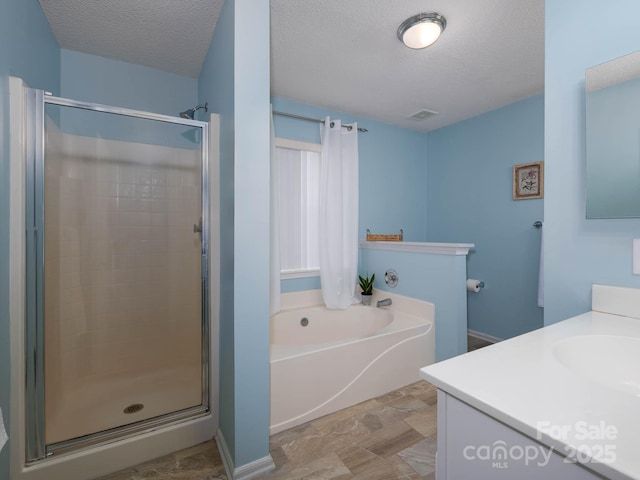 11911 Brownestone View Dr, Charlotte, NC 28269 - bathroom with a stall shower, a bath, vanity, a textured ceiling, and stone finish floors