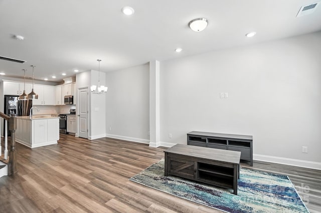 334 Ladybird Ln, Pineville, NC 28134 - unfurnished living room featuring dark wood-style floors, a chandelier, and recessed lighting