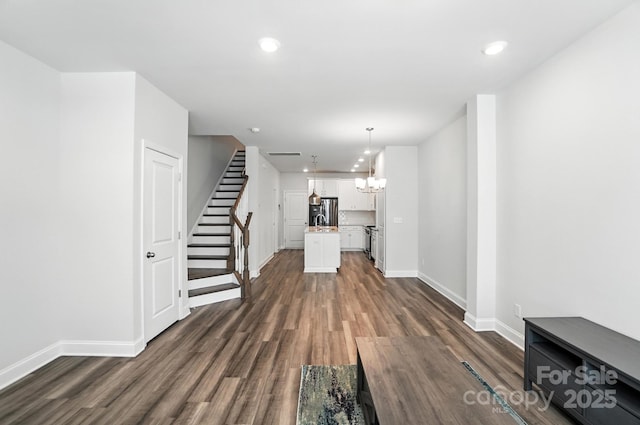 334 Ladybird Ln, Pineville, NC 28134 - unfurnished living room with dark wood-style flooring, a chandelier, recessed lighting, and stairs