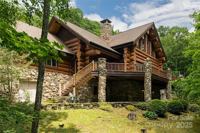 303 Flying Hawk Trl, Waynesville, NC 28786 - back of house with stone siding, log exterior, a chimney, and stairs