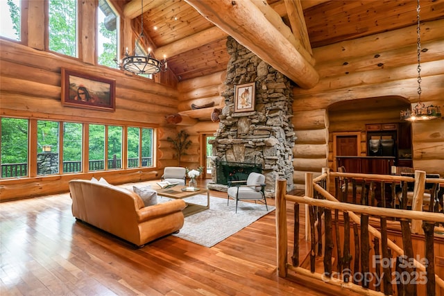 303 Flying Hawk Trl, Waynesville, NC 28786 - living room with log walls, a wood ceiling with exposed beams, high vaulted ceiling, wood-type flooring, and a fireplace