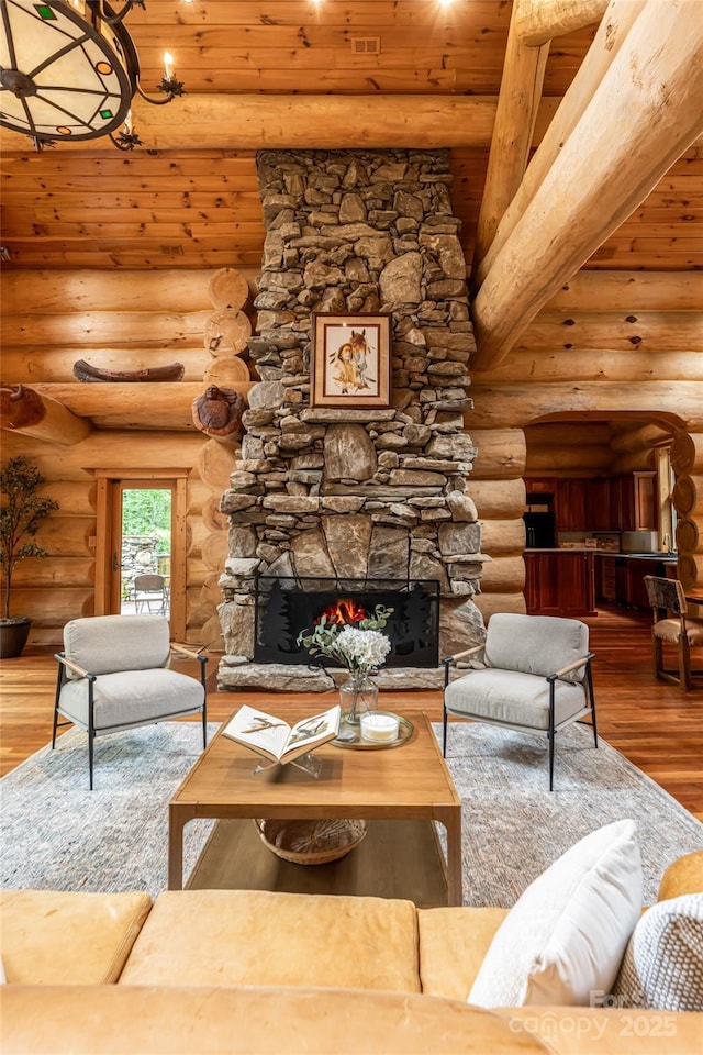 303 Flying Hawk Trl, Waynesville, NC 28786 - living area featuring wood ceiling, rustic walls, a stone fireplace, wood finished floors, and a chandelier