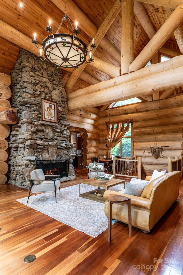 303 Flying Hawk Trl, Waynesville, NC 28786 - living room with wooden ceiling, a chandelier, log walls, hardwood / wood-style floors, and a fireplace