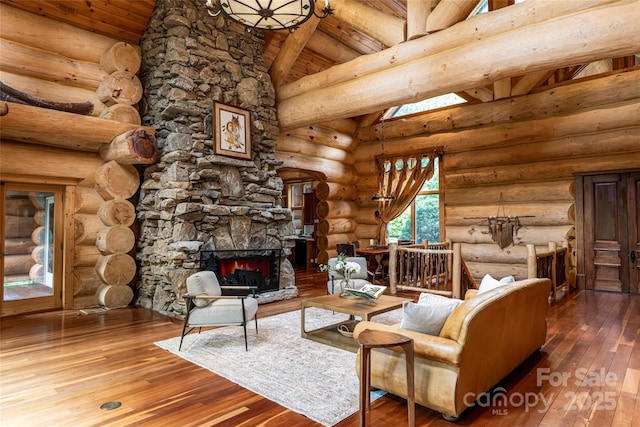 303 Flying Hawk Trl, Waynesville, NC 28786 - living area with wood ceiling, hardwood / wood-style floors, a stone fireplace, and log walls