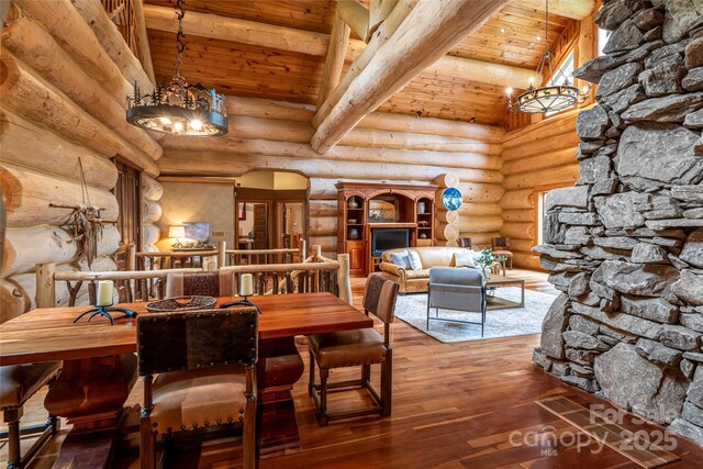 303 Flying Hawk Trl, Waynesville, NC 28786 - dining space featuring a wooden ceiling with exposed beams, a chandelier, wood-type flooring, and rustic walls