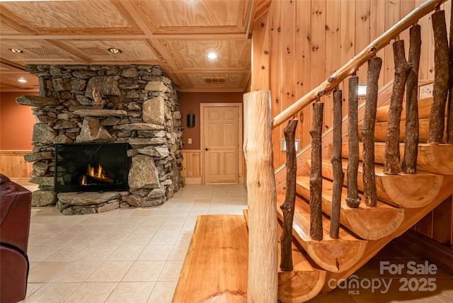 303 Flying Hawk Trl, Waynesville, NC 28786 - staircase with tile patterned flooring, a fireplace, a wainscoted wall, and wood walls