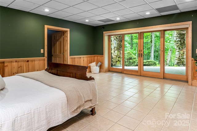 303 Flying Hawk Trl, Waynesville, NC 28786 - bedroom with a wainscoted wall, access to exterior, wooden walls, a drop ceiling, and light tile patterned floors