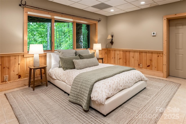 303 Flying Hawk Trl, Waynesville, NC 28786 - bedroom featuring a wainscoted wall, wooden walls, a drop ceiling, and tile patterned floors