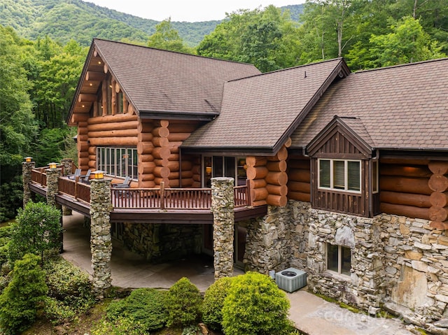 303 Flying Hawk Trl, Waynesville, NC 28786 - back of property featuring stone siding, log exterior, a deck with mountain view, and a forest view