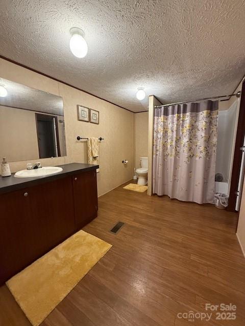 2418 6th Ave SW, Hickory, NC 28602 - full bathroom featuring vanity, wood finished floors, and a textured ceiling