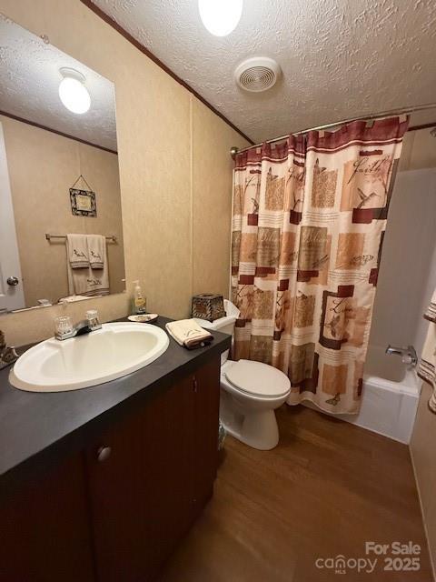 2418 6th Ave SW, Hickory, NC 28602 - full bath with wood finished floors, vanity, a textured ceiling, and shower / bath combo with shower curtain