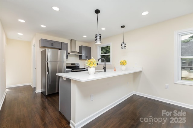 803 Irene Ave, Kannapolis, NC 28083 - kitchen featuring stainless steel appliances, wall chimney exhaust hood, a peninsula, dark wood finished floors, and gray cabinetry