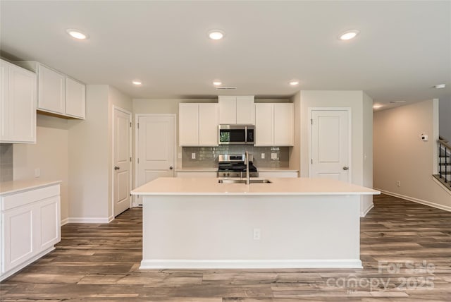136 Dorian Pl, Troutman, NC 28166 - kitchen featuring appliances with stainless steel finishes, decorative backsplash, a center island with sink, light countertops, and recessed lighting