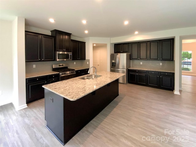 2382 Drake Mill Ln SW, Concord, NC 28025 - kitchen with appliances with stainless steel finishes, a center island with sink, light wood finished floors, and recessed lighting