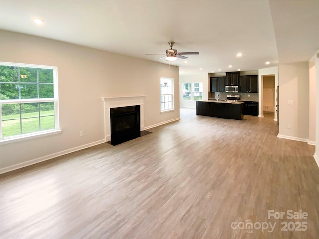 2382 Drake Mill Ln SW, Concord, NC 28025 - unfurnished living room with ceiling fan, light wood-style flooring, a fireplace with flush hearth, and recessed lighting