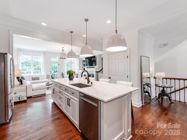 3036 Luke Crossing Dr, Charlotte, NC 28226 - kitchen with appliances with stainless steel finishes, open floor plan, a kitchen island with sink, crown molding, and light stone counters