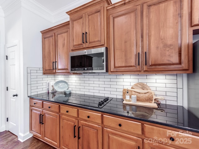 3036 Luke Crossing Dr, Charlotte, NC 28226 - kitchen with stainless steel microwave, brown cabinets, tasteful backsplash, dark wood-style floors, and ornamental molding