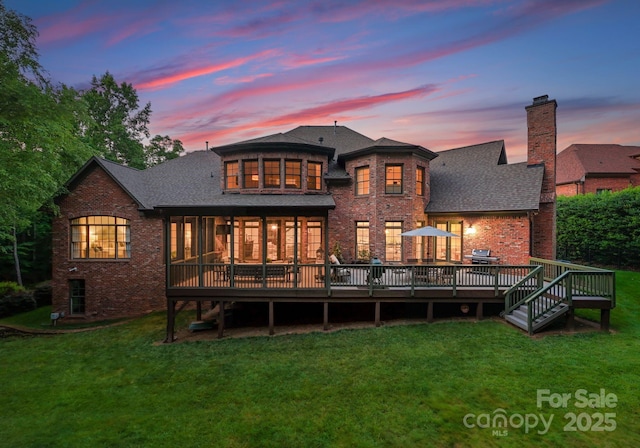 408 Covington Xing, Matthews, NC 28104 - back of property at dusk with brick siding, a yard, roof with shingles, and a wooden deck