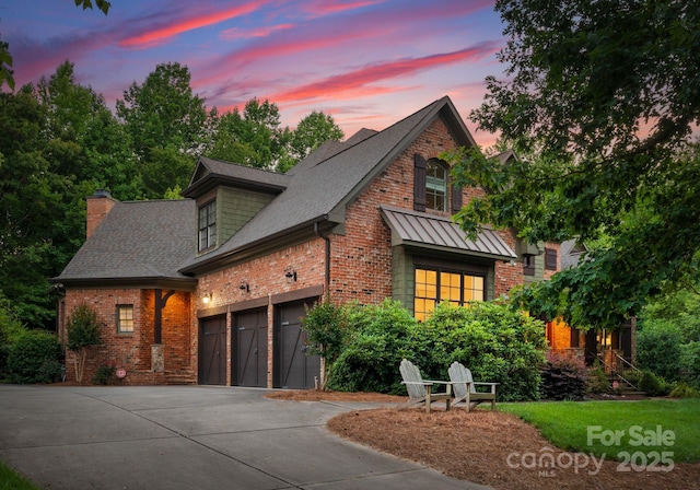 408 Covington Xing, Matthews, NC 28104 - view of front of house featuring brick siding, driveway, a chimney, a shingled roof, and a standing seam roof