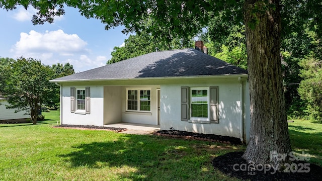 921 Spencer Rd NE, Conover, NC 28613 - view of front of house with stucco siding, a front lawn, a shingled roof, and a chimney