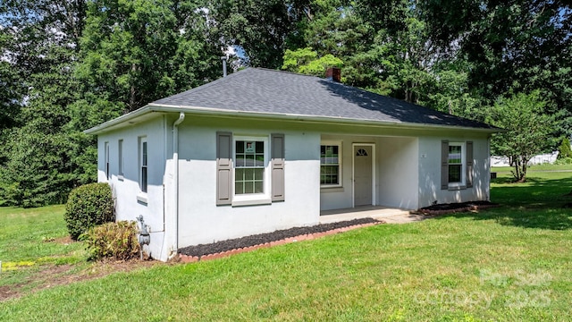 921 Spencer Rd NE, Conover, NC 28613 - view of front of home featuring stucco siding, a front lawn, a shingled roof, and a chimney