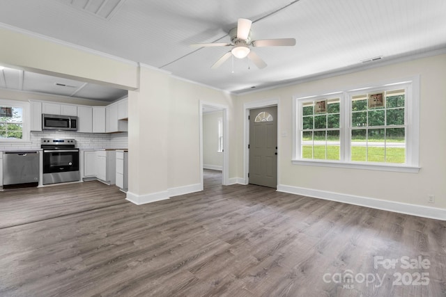 921 Spencer Rd NE, Conover, NC 28613 - unfurnished living room featuring a ceiling fan, plenty of natural light, ornamental molding, and dark wood-type flooring