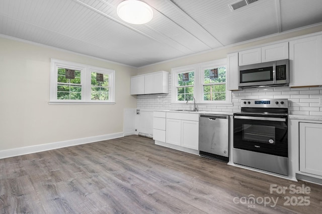 921 Spencer Rd NE, Conover, NC 28613 - kitchen with appliances with stainless steel finishes, ornamental molding, tasteful backsplash, light countertops, and plenty of natural light