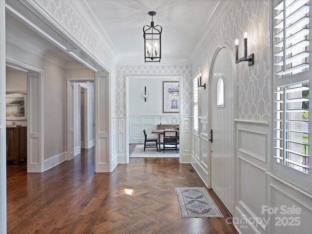 6314 Saint Stephen Ln, Charlotte, NC 28210 - entrance foyer with a chandelier, a decorative wall, crown molding, a wainscoted wall, and wallpapered walls