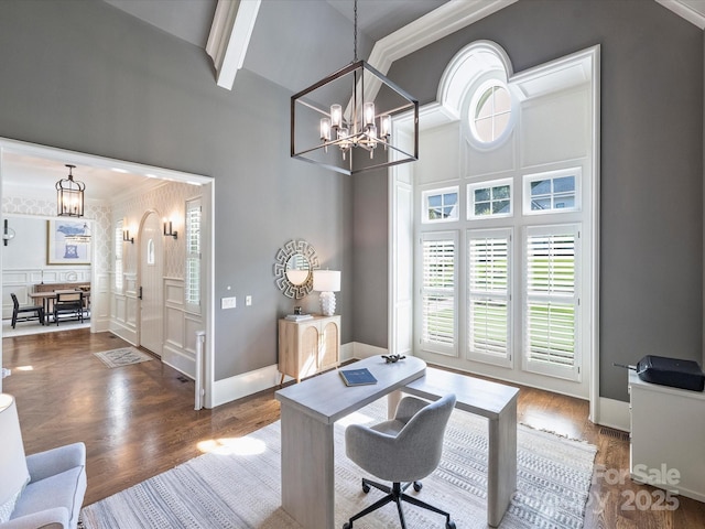 6314 Saint Stephen Ln, Charlotte, NC 28210 - home office with a chandelier, a towering ceiling, a decorative wall, wood finished floors, and crown molding
