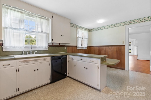 1520 21st Ave NE, Hickory, NC 28601 - kitchen featuring black dishwasher, wainscoting, a peninsula, wood walls, and light floors