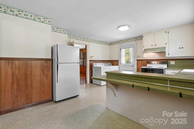 1520 21st Ave NE, Hickory, NC 28601 - kitchen featuring white appliances, separate washer and dryer, under cabinet range hood, wainscoting, and light flooring