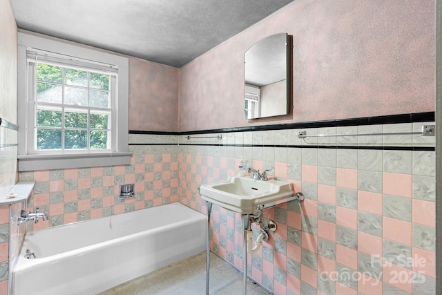 1520 21st Ave NE, Hickory, NC 28601 - bathroom with a bath, a textured ceiling, tile walls, and wainscoting
