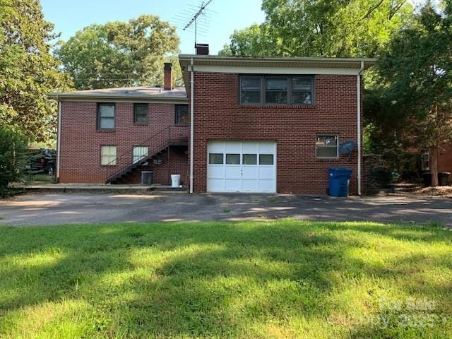 209 8th Ave NW, Hickory, NC 28601 - back of property featuring driveway, an attached garage, brick siding, and stairs