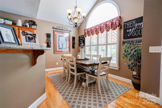 116 Camille Dr, Shelby, NC 28150 - dining room featuring a chandelier, light wood finished floors, lofted ceiling, and a textured ceiling