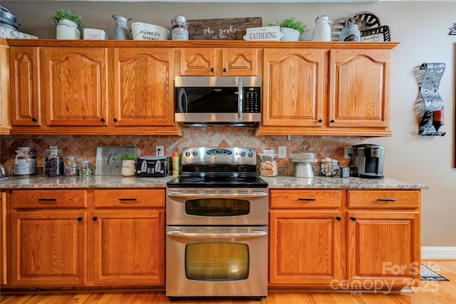 116 Camille Dr, Shelby, NC 28150 - kitchen with stainless steel appliances, decorative backsplash, light wood-type flooring, and brown cabinets