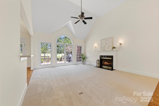 2241 Flagstick Dr, Matthews, NC 28104 - unfurnished living room with a glass covered fireplace, high vaulted ceiling, carpet, and a ceiling fan